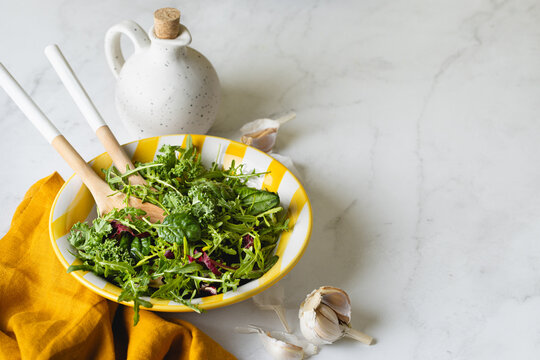 Fresh mixed greens in a vibrant yellow plate