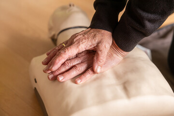 Hands performing CPR on a dummy in training session