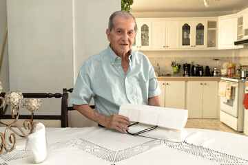 Latino senior citizen with a white shopping bag