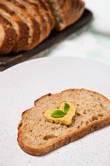 Close up of Toast with Heart-Shaped Hummus and green herb leaves