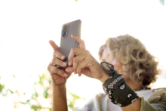Woman photographing urban garden on a sunny day