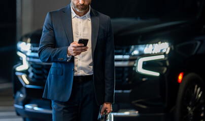 Businessman reading message on phone at parking. Business texting message. Online business messaging. Business man in suit use phone. Messaging businessman check email. Copy space