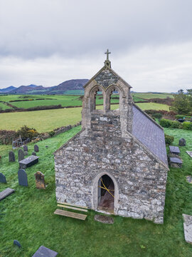 Aerial drone view of brick church with cemetery and sheep farm in remote Welsh countryside