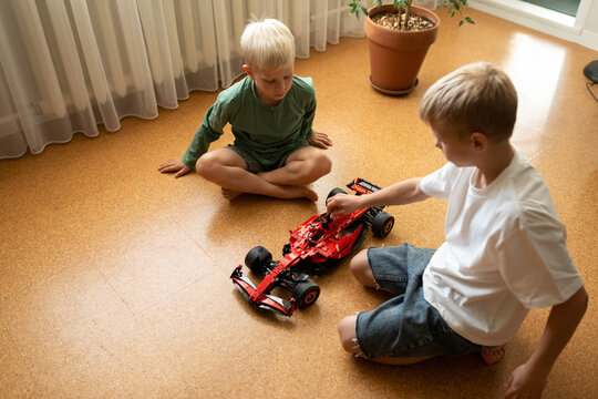 Brothers playing with toy car in cozy home setting