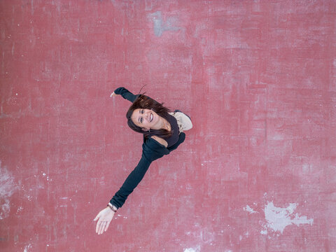 Woman smiling while reaching out on a textured surface