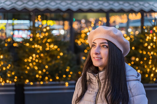 Girl enjoying winter lights in Paris with a smile