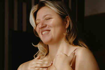 Joyful caucasian female adult with blonde hair relaxing indoors