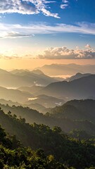 Golden sunrise over hazy, layered green mountains and a vast, cloudy blue sky