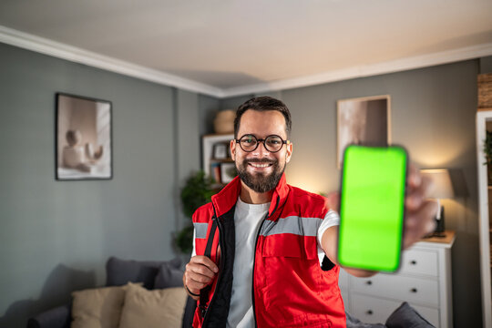 Paramedic smiling showing phone with green screen