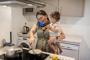 Multitasking mother in the kitchen with her son