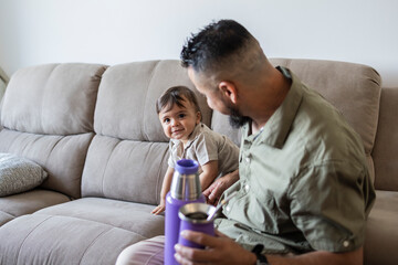 Father bonding with son on cozy living room couch