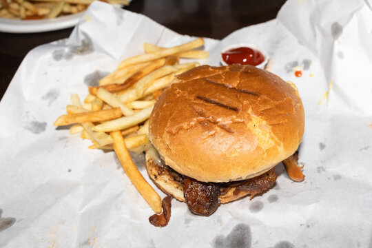 Juicy burger with crispy fries and ketchup on paper