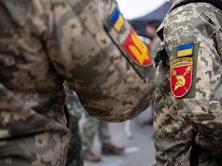 Detail of Ukrainian armed forces patches with national flag and artillery unit emblem on digital...