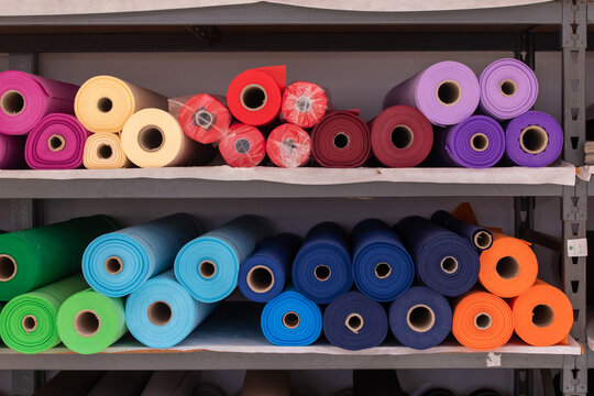 Colorful rolls of fabric on display in a textile store