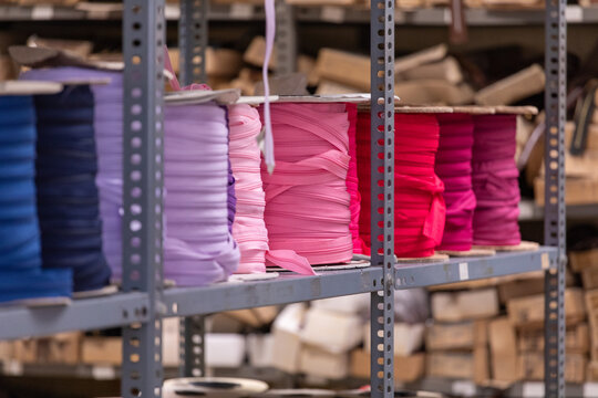 Colorful fabric rolls on industrial storage shelves
