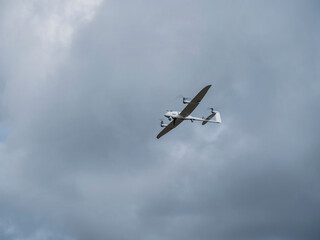 Reconnaissance UAV flying against cloudy sky during tactical military surveillance and monitoring mission
