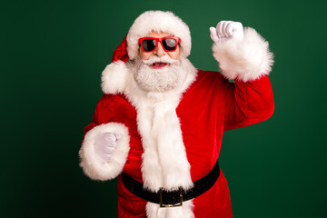 Santa in red suit with white fur trimming wearing red sunglass celebrates Christmas for festive advertising and family celebration