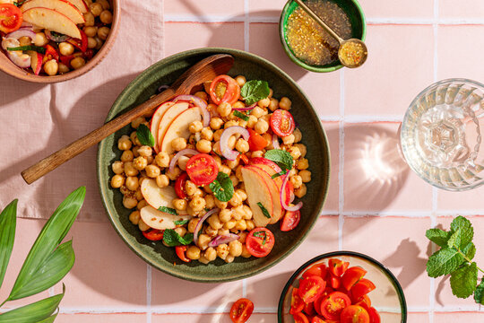 Fresh chickpea salad with apples and mint on tiles