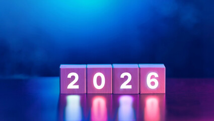 Glowing 2026 numbers on wooden cubes with neon lights, reflected on a glossy surface. Modern concept of new year celebration, futuristic design, and bright optimism.