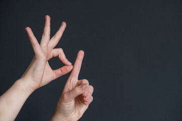 Woman showing the word goal in Russian sign language on black background. 