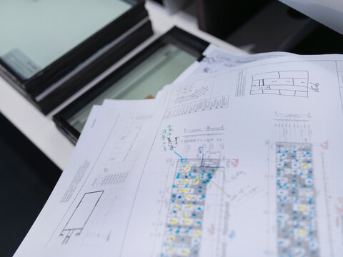 Architectural blueprints with building materials and color samples spread on work surface for review - Powered by Adobe