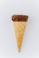 Chocolate ice cream cone isolated on white background, minimalist summer dessert concept