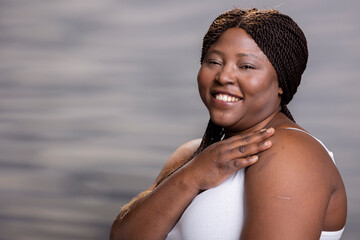 Portrait of african american happy girl with candid smile and soft skin. Beautiful depiction of feminine empowerment, skincare and self acceptance, perfect for modern wellness advertisement.