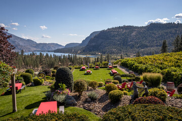 Scenic view of red picnic tables overlooking a vineyard, lake and mountains