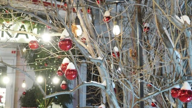 Street decorations before Christmas, multi-colored lights in Christmas balls, Christmas trees under the snow, beautifully lit streets before the New Year. a festively decorated outdoor Christmas tree 