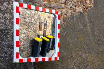 mirror reflection of bins in alley
