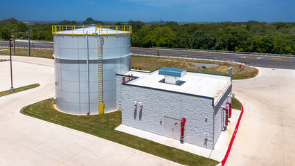  97,000 Gallon Carbon Bolted Steel water Tank, with low Profile Roof, next to pump station building  