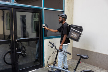 Food delivery worker with a backpack approaching a front door, delivering restaurant takeaway meal...