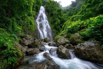 Naklejka premium Serene waterfall cascading through lush green forest at midday
