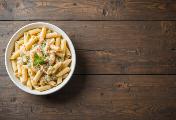 Penne Pasta with Creamy Alfredo Sauce and Copy Space on Rustic Wooden Background