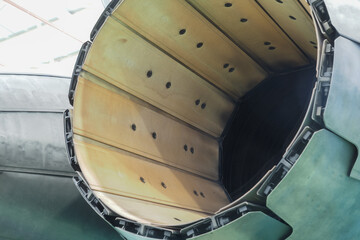Extreme close view inside the afterburner liner showing cooling holes and nozzle petal edge on a twin engine multirole fighter jet