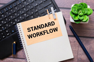 Standard workflow text on open notepad on white keyboard.