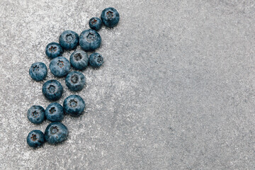 Fresh blueberries arranged on a textured gray surface for a healthy snack or dessert idea