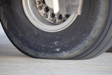 Detailed macro view of a single landing gear tire with visible hub bolts and rim assembly on a tactical transport aircraft