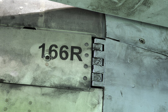 Detail view of a hinge line and surface panel with numeric marking on the fuselage of a multirole fighter jet