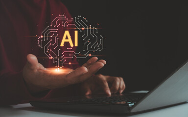 Close up of hand holding glowing AI hologram above laptop, symbolizing artificial intelligence,...