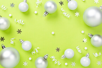Grey Christmas balls with decor on color background, top view