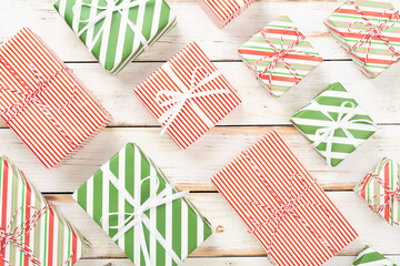 Fototapeta premium Many striped Christmas gift boxes on wooden background, top view