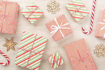 Obraz premium Many striped Christmas gift boxes on wooden background, top view