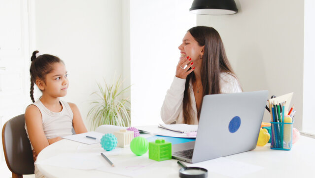 The speech therapist teaches the girl to pronounce words correct