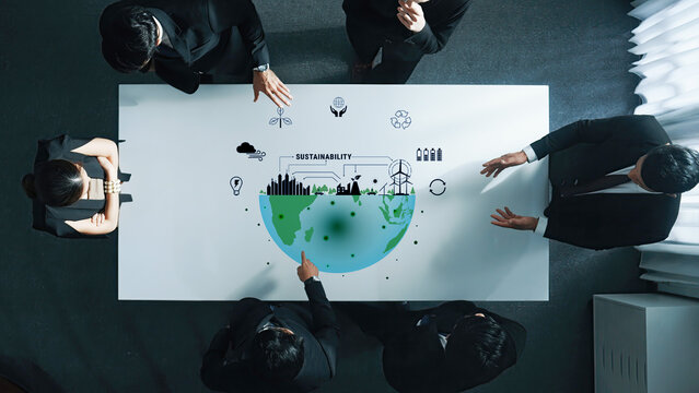 A diverse business team collaborates in a modern office setting to discuss sustainability strategies, illustrated with a green globe and eco-friendly icons. Trope