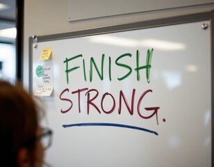 Finish Strong Message on Whiteboard in Office Setting - Business Goal, Motivation, Success, and Teamwork Concept. Ideal for presentations and office materials.