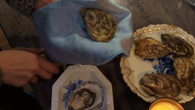 Detailed oyster shuck demonstration, Upclose Sequence of Extracting Oyster Using Towel and Blade
