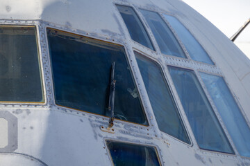 Close-up of cockpit window frame and riveted fuselage showing aging details of preserved aircraft on outdoor display