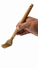 hand holding a brown silicone basting brush with wooden handle isolated on white background