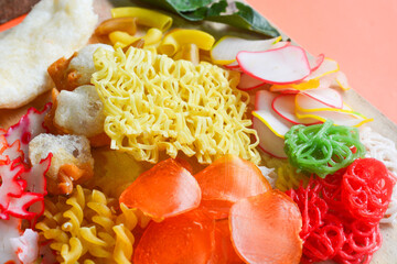 Crackers, cuanki, noodles, and complete dry seblak seasoning on a wooden tray